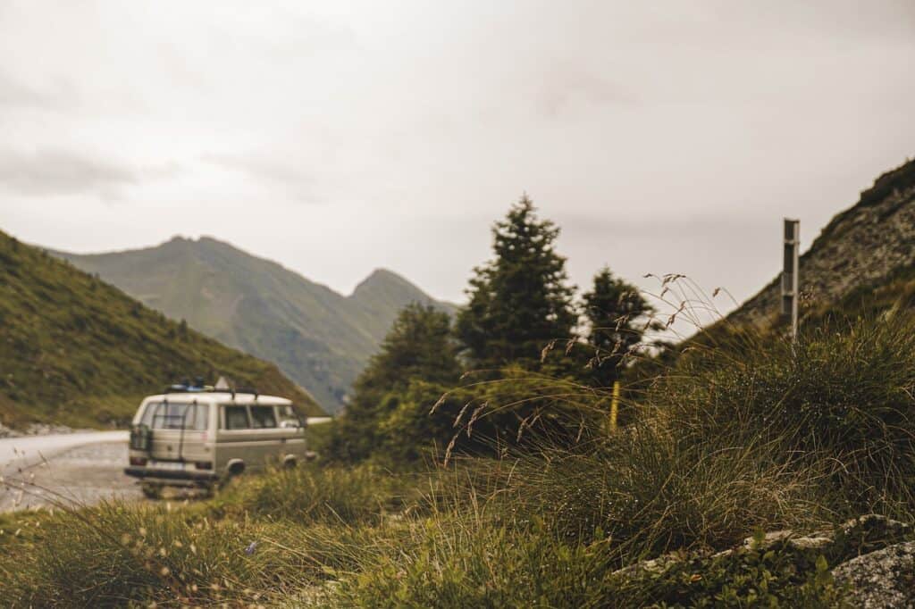 van Volkswagen qui est garé en bord de route avec un magnifique paysage de montagne 